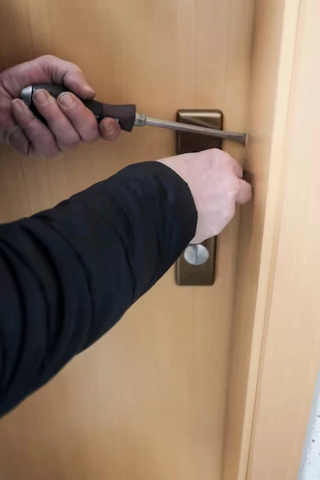 En låsesmed reparerer en dørlås